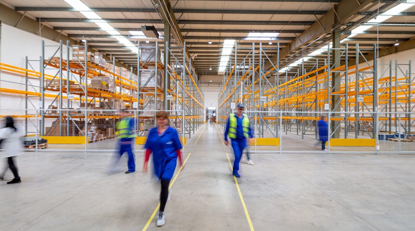 A worker in safety gear conducting a walk-through of an industrial facility.